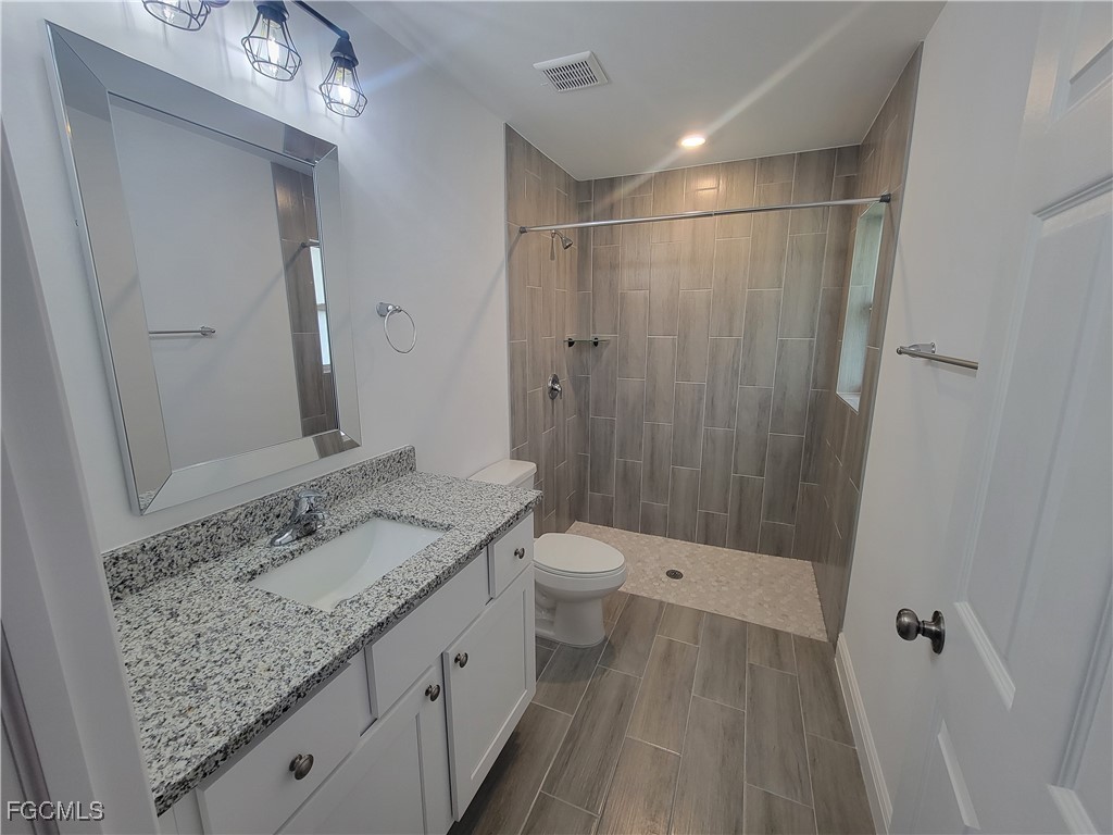 2156-2154 Edison Avenue Fort Myers, FL 33901 - Photo 15 of 38 a bathroom with a granite countertop sink toilet and shower