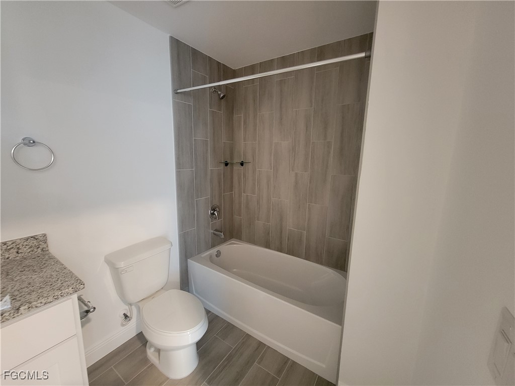 2156-2154 Edison Avenue Fort Myers, FL 33901 - Photo 16 of 38 a bathroom with a granite countertop toilet and a shower