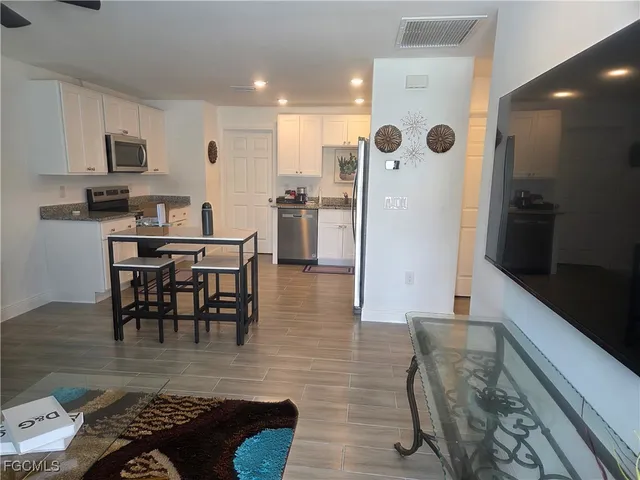 a living room with furniture kitchen view and a dining table
