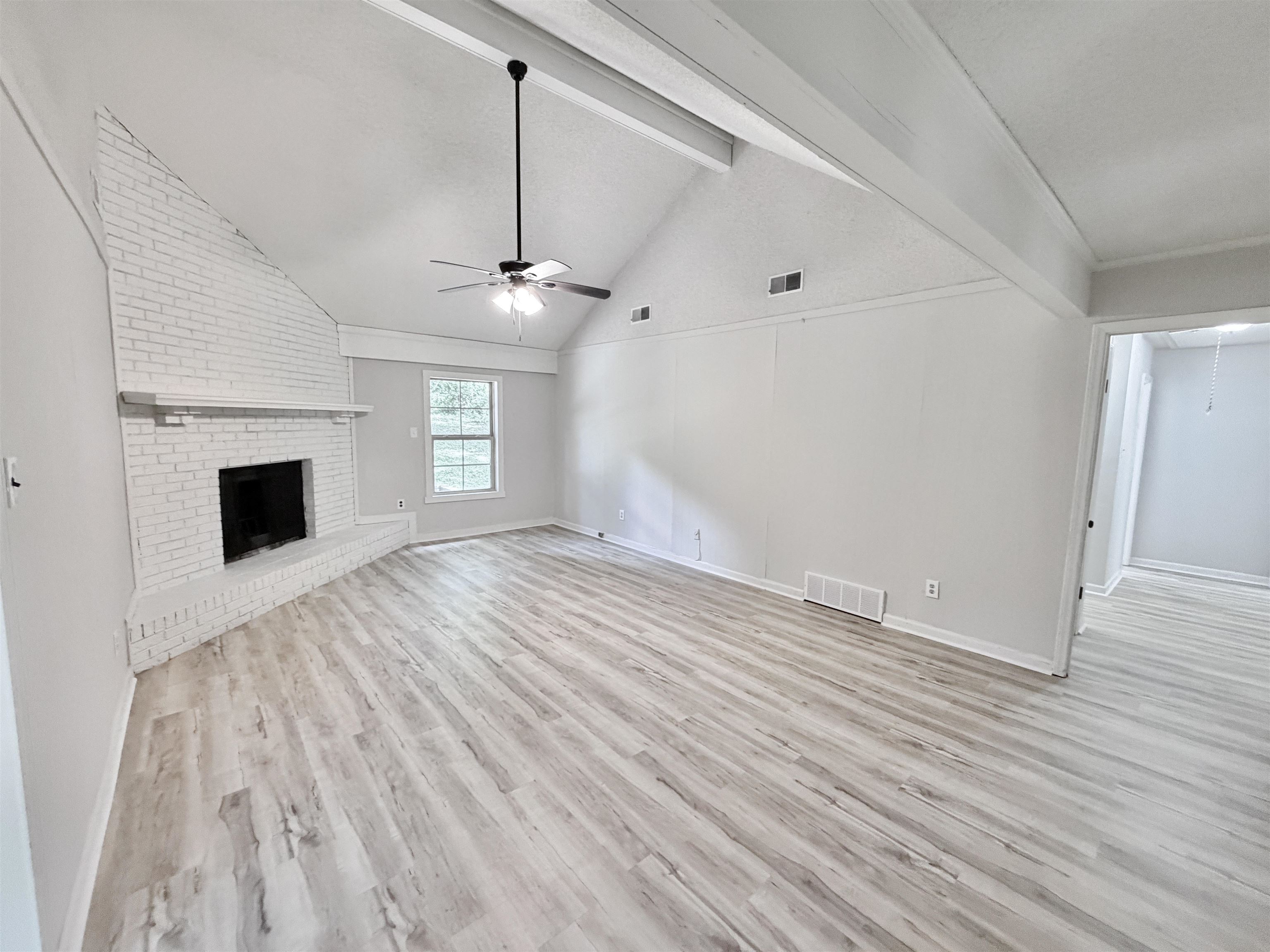 4278 Auburn Road Memphis, TN 38116 - Photo 5 of 28 Living area featuring a painted brick fireplace, vaulted ceiling with exposed beams, wood-finish flooring, and a ceiling fan