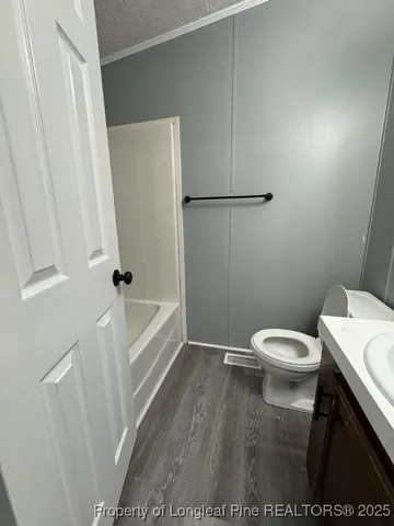 a white toilet sitting next to a white sink