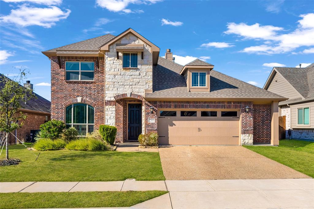 View of front of home featuring a shingled roof, brick siding, driveway, and a front yard