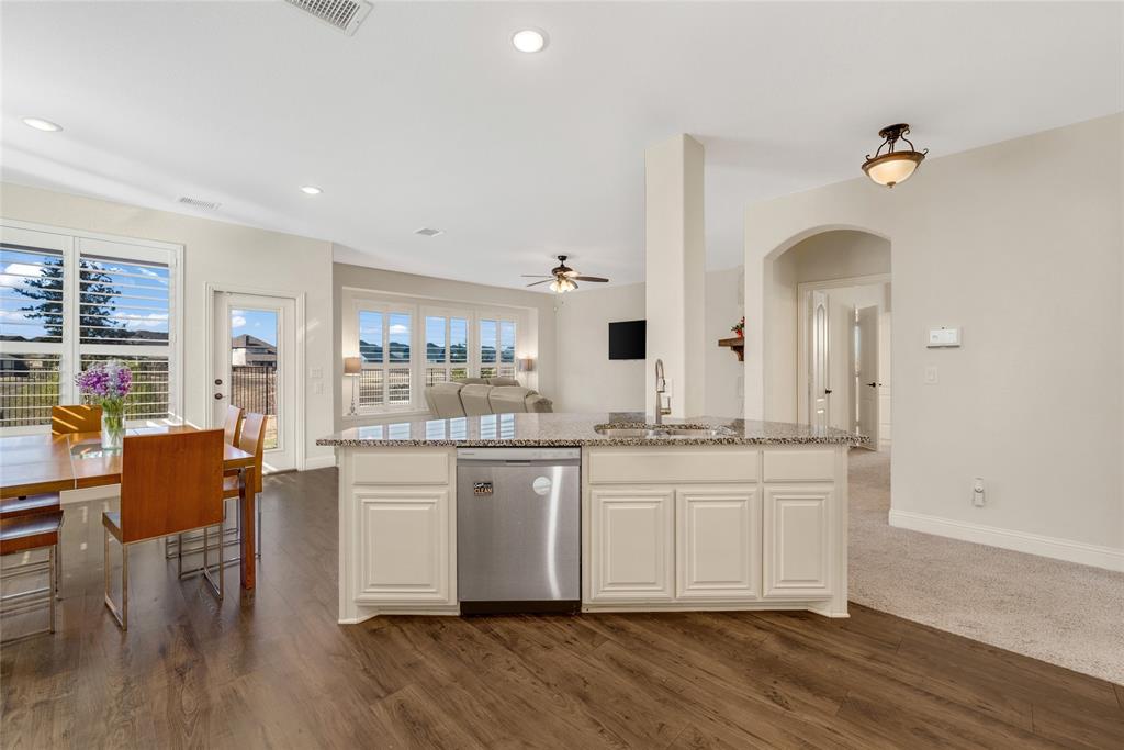 2203 Vista Ridge Road Melissa, TX 75454 - Photo 40 of 40 Kitchen with light stone countertops, open floor plan, dishwasher, an island with sink, and arched walkways