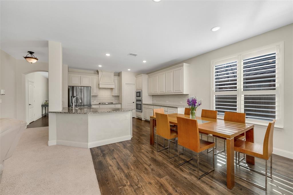 2203 Vista Ridge Road Melissa, TX 75454 - Photo 9 of 40 Kitchen featuring light stone countertops, cream cabinets, arched walkways, dark wood-type flooring, and appliances with stainless steel finishes