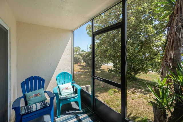 a view of a living room with a floor to ceiling window and wooden floor