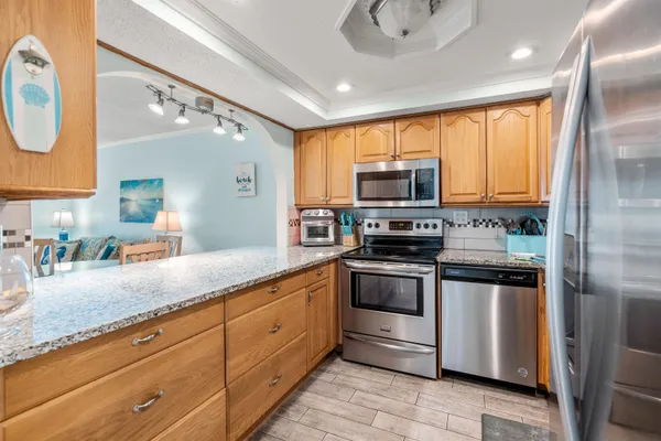 a kitchen with stainless steel appliances granite countertop a refrigerator a stove top oven a sink and dishwasher