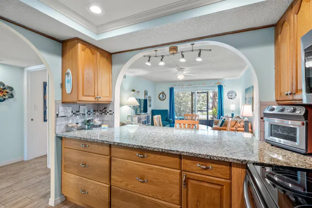 a kitchen with stainless steel appliances kitchen island granite countertop a stove and a sink