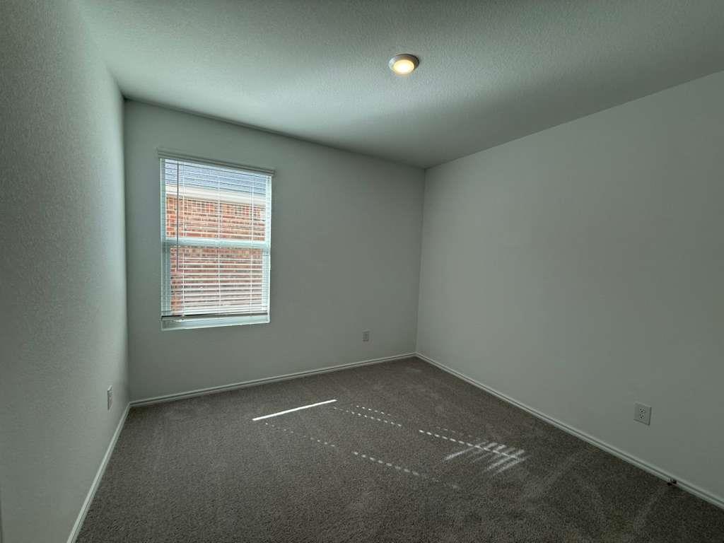 545 Sormonne Loop Kyle, TX 78640 - Photo 26 of 39 Spare room featuring dark colored carpet and a textured ceiling