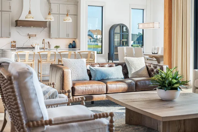 a kitchen with stainless steel appliances kitchen island granite countertop a stove a refrigerator a oven a dining table and chairs with wooden floor