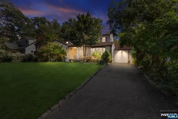 a view of a house with a yard and pathway