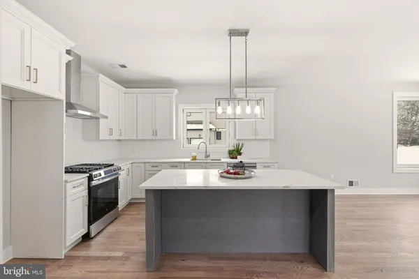 a kitchen with kitchen island granite countertop stainless steel appliances a counter space a sink and cabinets