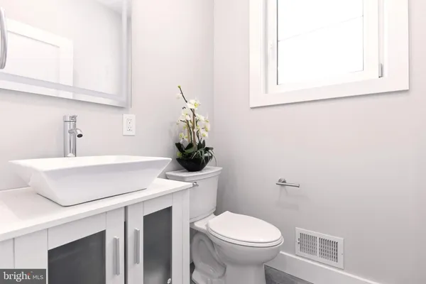 a bathroom with a sink a toilet and mirror
