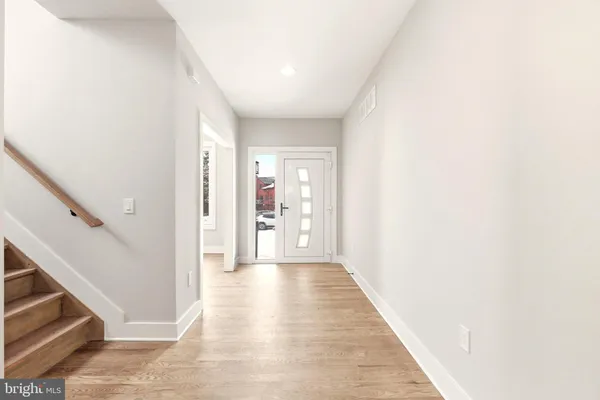 a view of a hallway with wooden floor and entryway