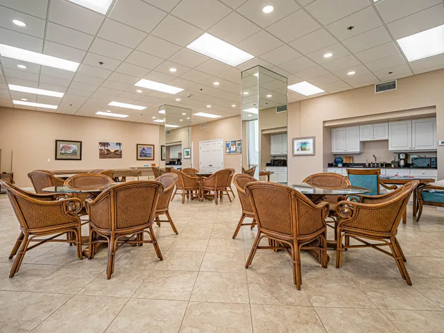 a dining room with furniture a large window and a book shelf