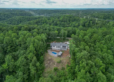 an aerial view of a house with a yard and trees