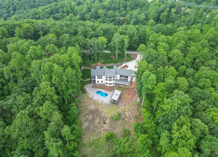 a view of a house with pool and chairs