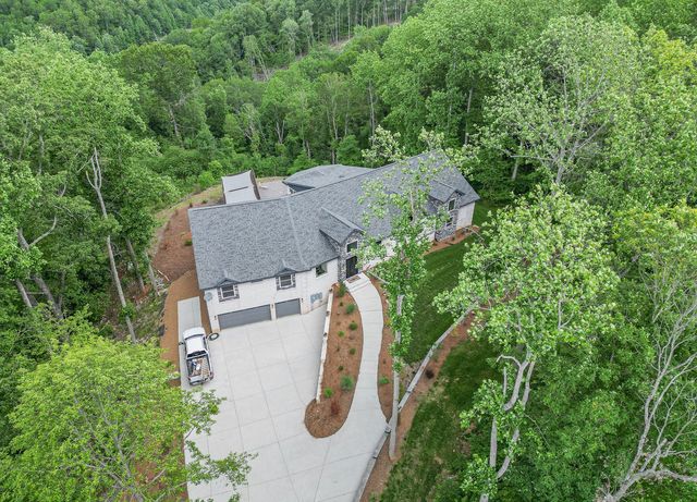 a view of a white house with a yard plants and a table and chairs