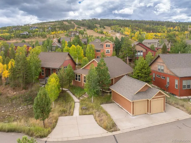 an aerial view of residential houses with outdoor space and ocean view