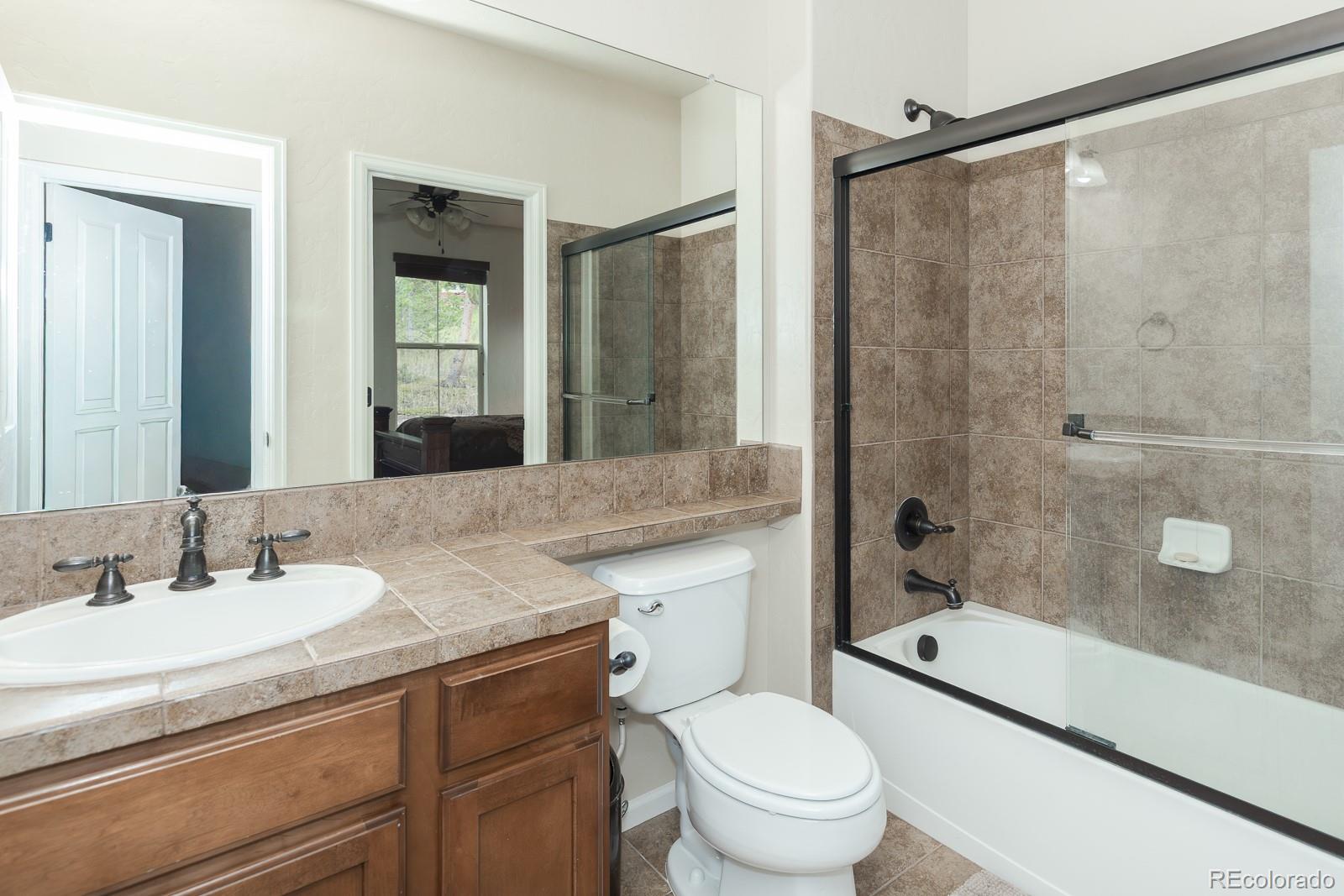 103 Timber Court Granby, CO 80446 - Photo 25 of 50 a bathroom with a granite countertop sink toilet and shower