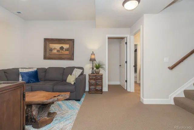 a living room with furniture and a hallway