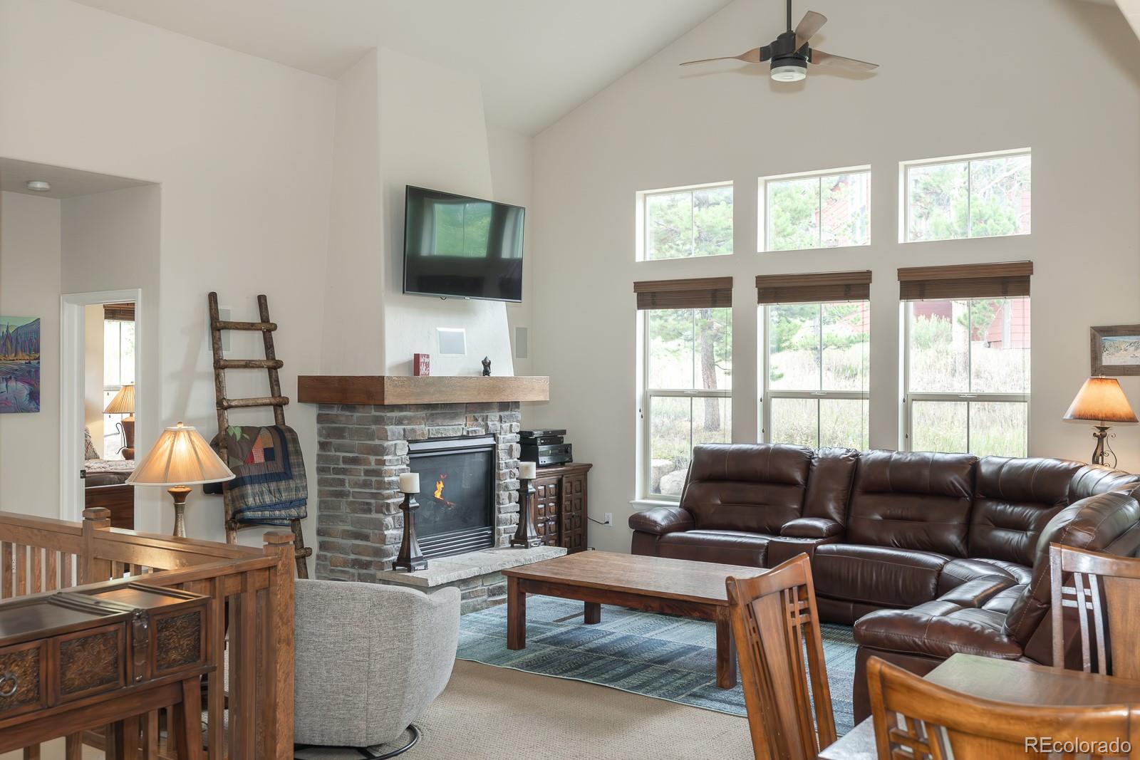 103 Timber Court Granby, CO 80446 - Photo 37 of 50 a living room with furniture a flat screen tv and a fireplace