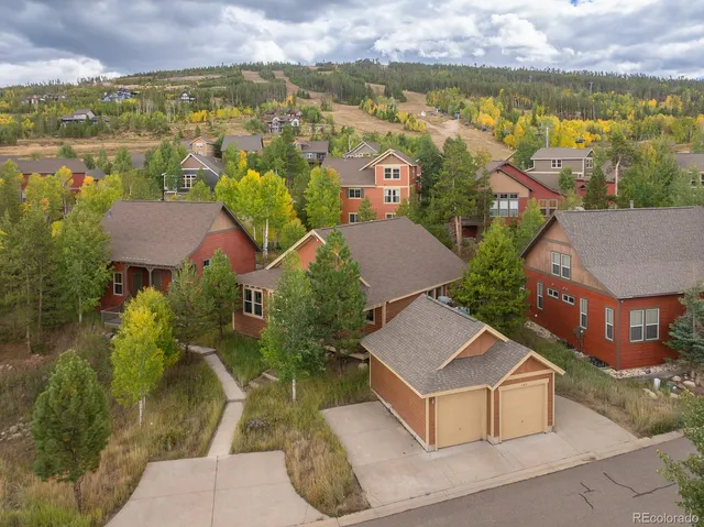 an aerial view of residential houses with outdoor space and ocean view