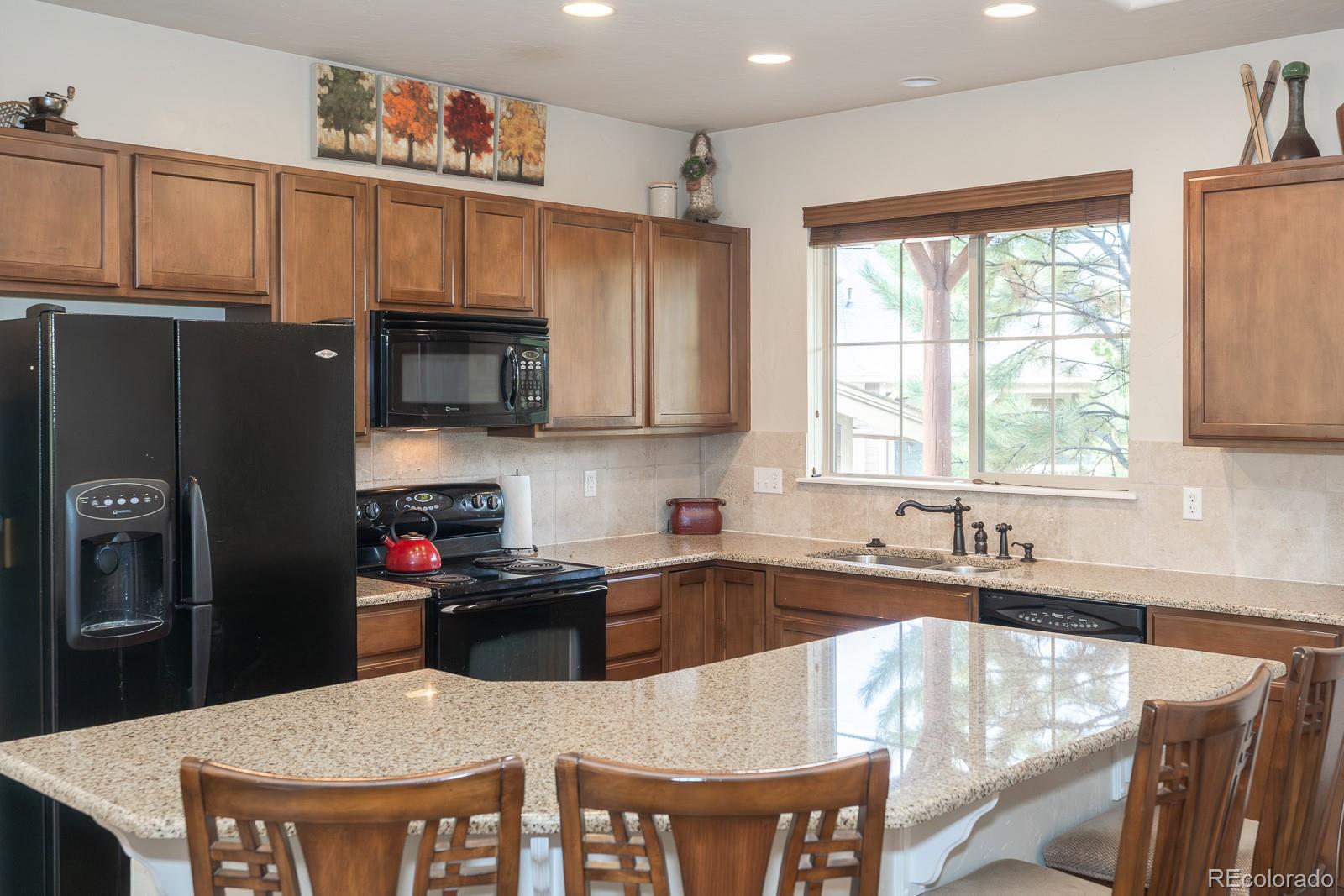 103 Timber Court Granby, CO 80446 - Photo 7 of 50 a kitchen with stainless steel appliances granite countertop a stove a refrigerator a sink a dining table and chairs