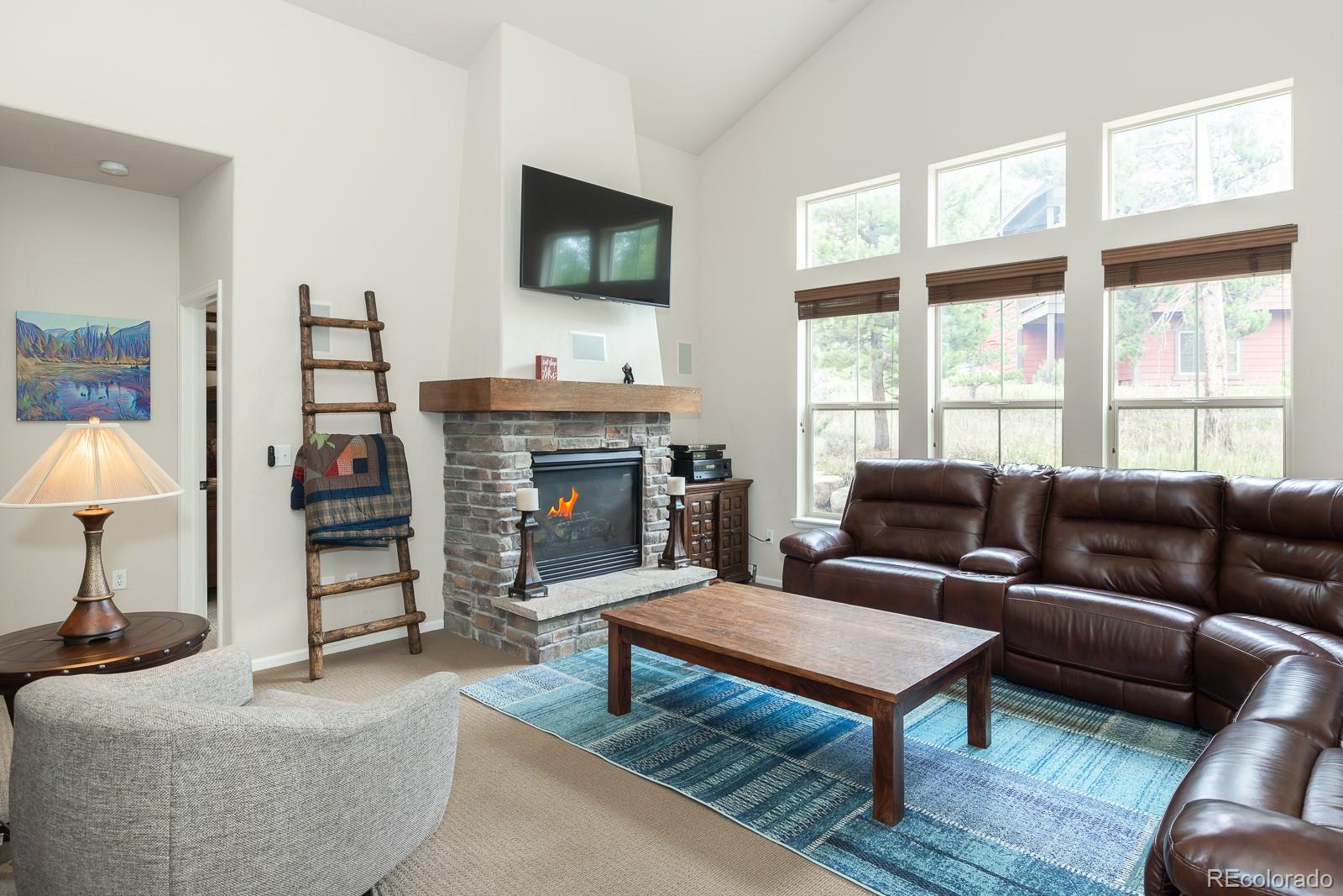 103 Timber Court Granby, CO 80446 - Photo 8 of 50 a living room with furniture a flat screen tv and a fireplace
