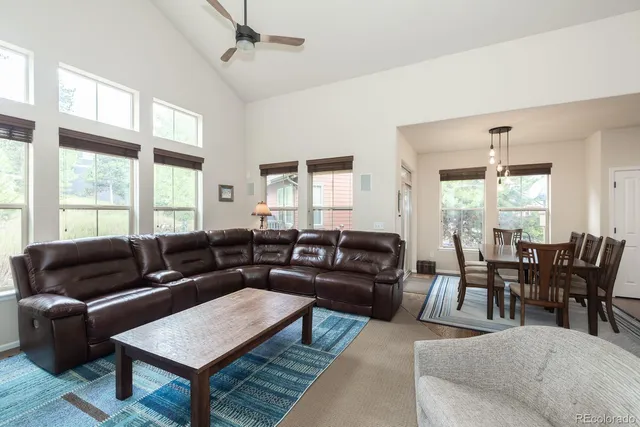 a living room with furniture a large window and a dining table