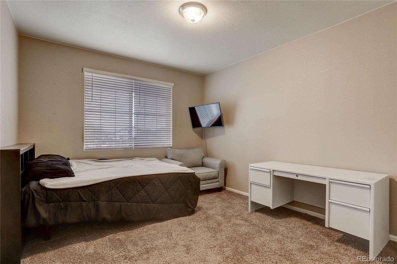 7104 Morrison Drive Frederick, CO 80530 - Photo 13 of 33 a bedroom with a bed and a night stand
