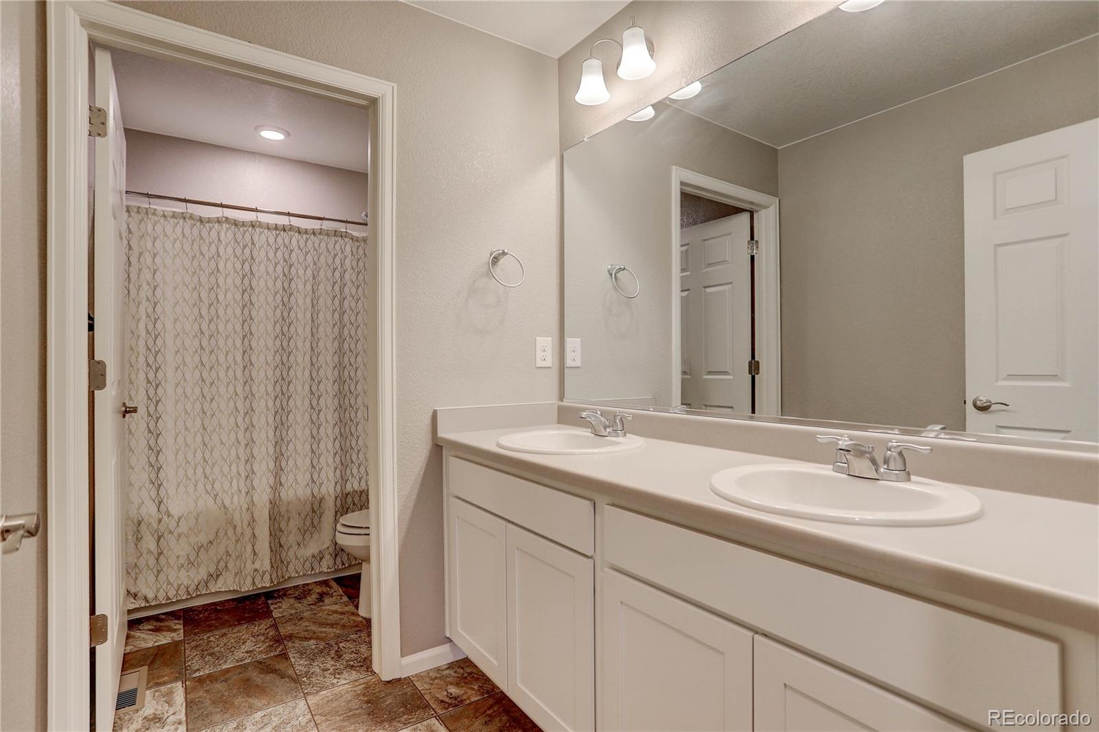 7104 Morrison Drive Frederick, CO 80530 - Photo 19 of 33 a bathroom with a sink double vanity and a mirror