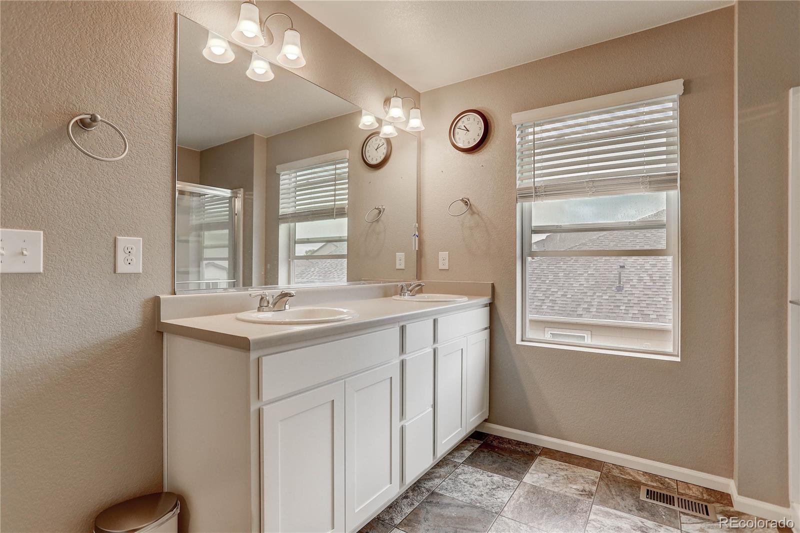 7104 Morrison Drive Frederick, CO 80530 - Photo 26 of 33 a bathroom with a sink a vanity and a mirror