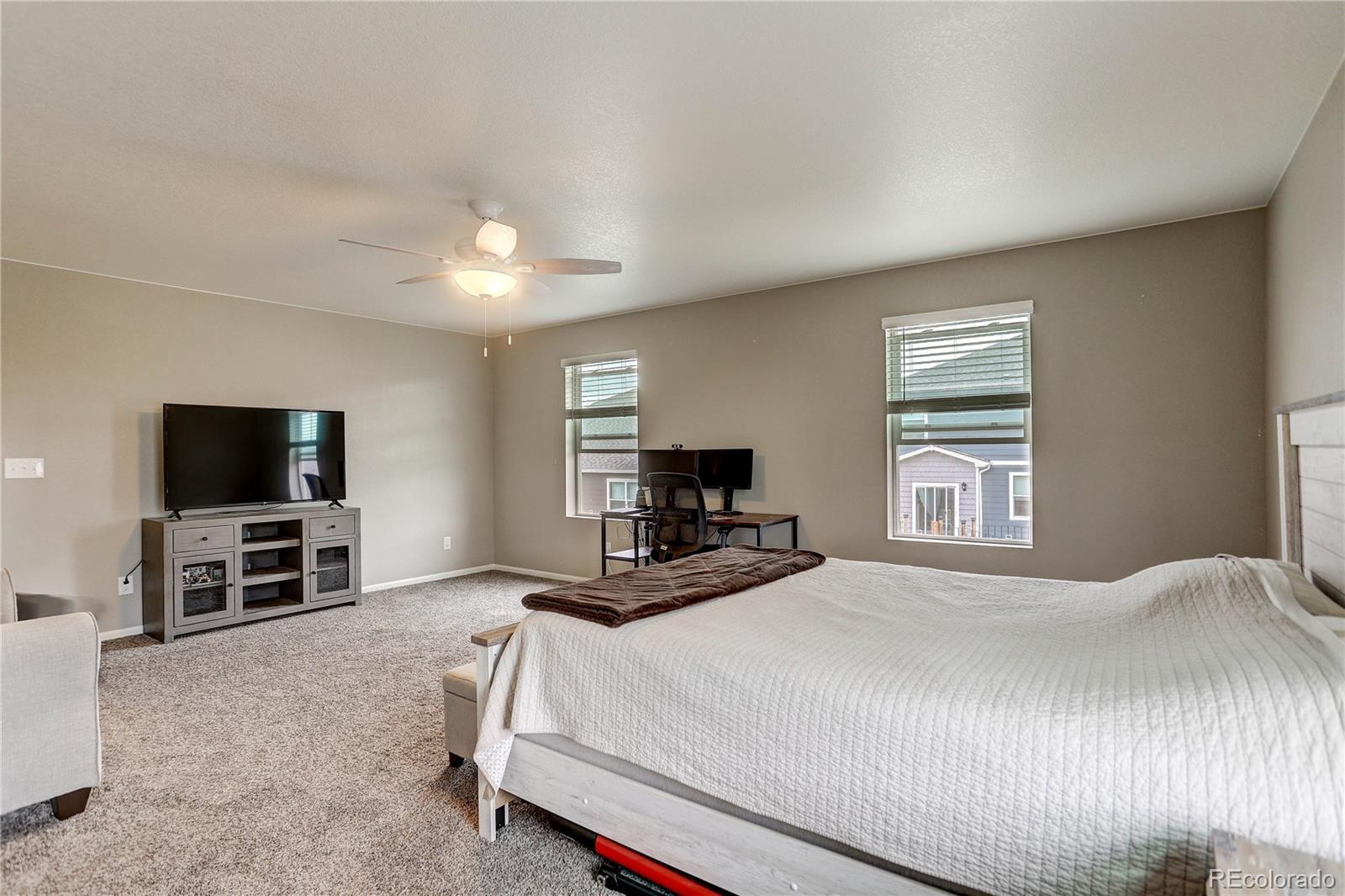 7104 Morrison Drive Frederick, CO 80530 - Photo 28 of 33 a bedroom with a bed and a flat screen tv