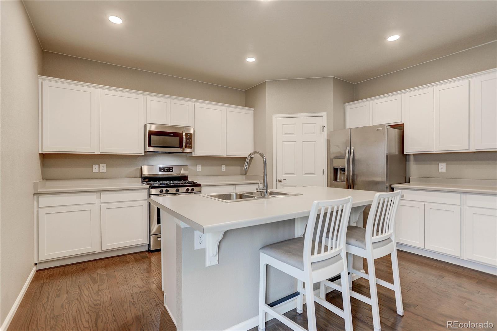 7104 Morrison Drive Frederick, CO 80530 - Photo 5 of 33 a kitchen with a stove a sink and a refrigerator