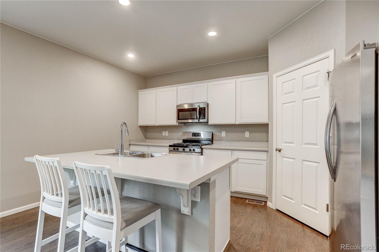 7104 Morrison Drive Frederick, CO 80530 - Photo 9 of 33 a kitchen with a white cabinets and refrigerator