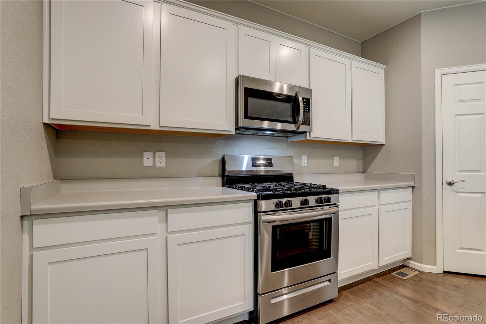 7104 Morrison Drive Frederick, CO 80530 - Photo 10 of 33 a kitchen with white cabinets and stainless steel appliances