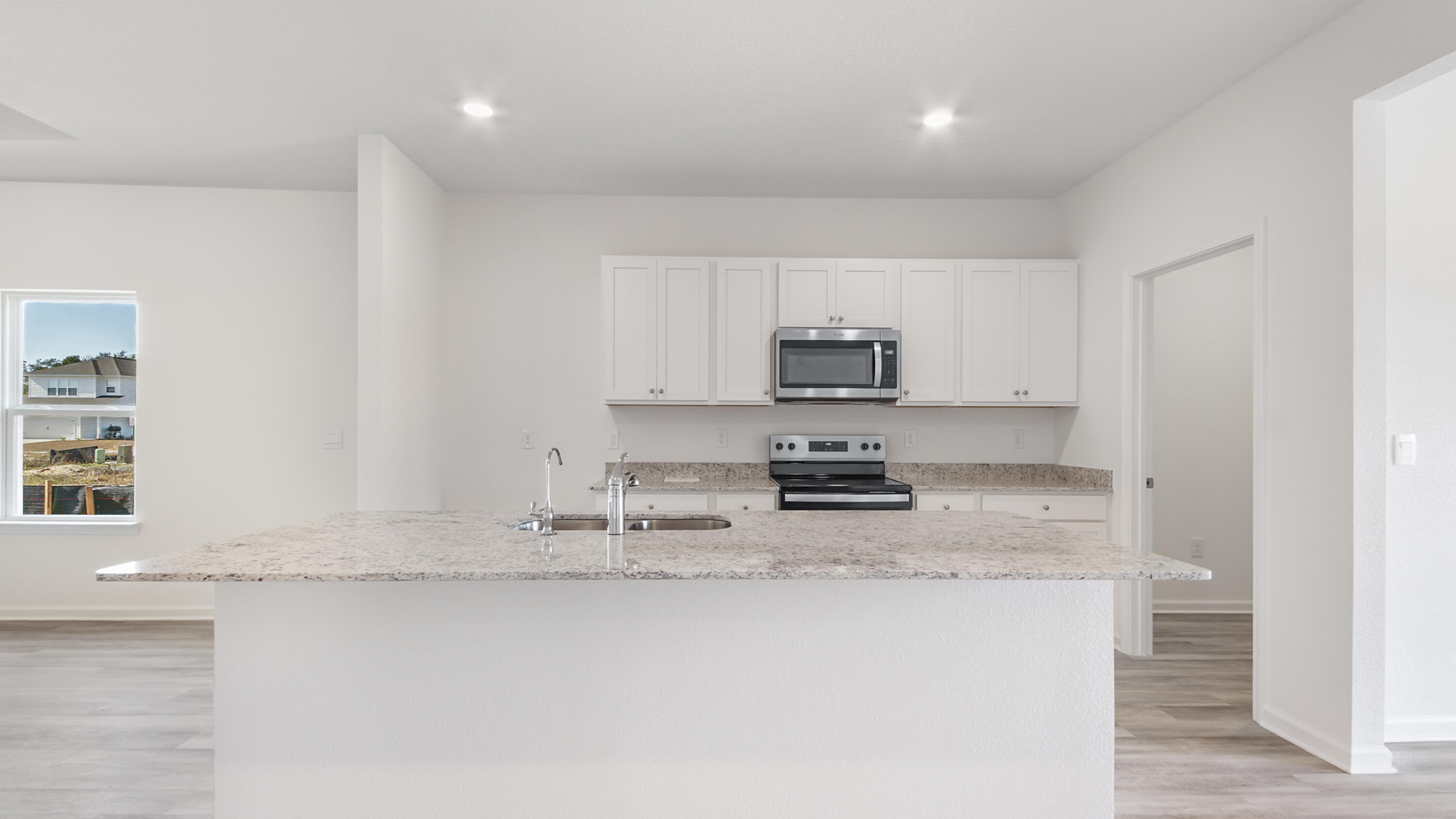 214 Sweetthorn Street Freeport, FL 32439 - Photo 30 of 36 a kitchen with stainless steel appliances granite countertop a sink a stove a microwave a sink and white cabinets