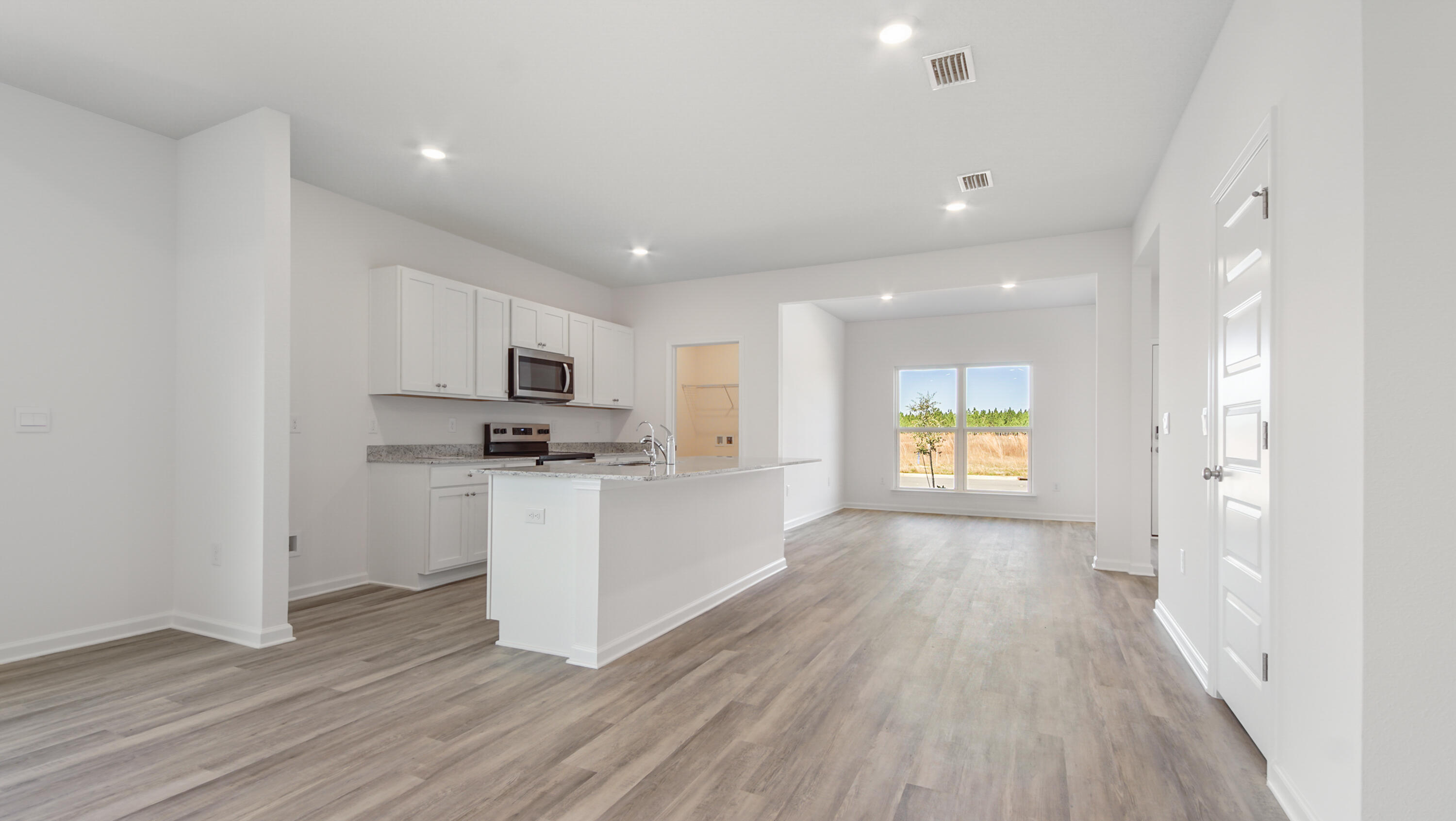 214 Sweetthorn Street Freeport, FL 32439 - Photo 7 of 36 a open kitchen with white cabinets and stainless steel appliances