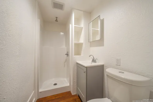 a bathroom with a sink a toilet and shower