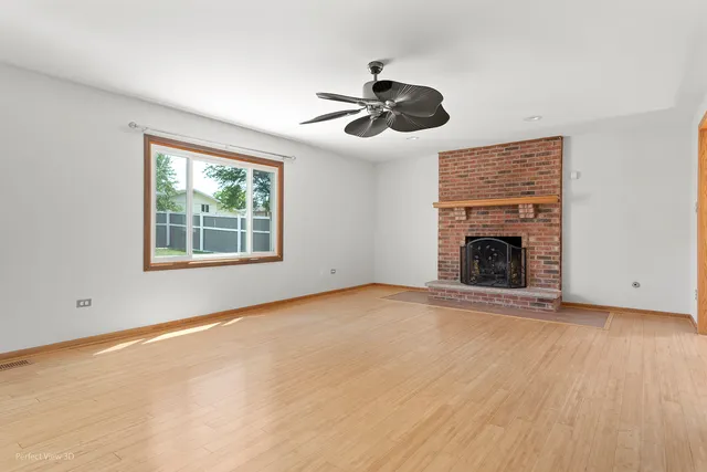 an empty room with windows and fireplace