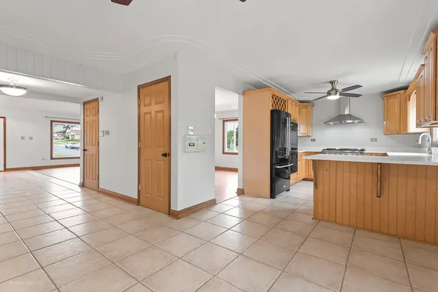 a view of a kitchen with refrigerator and wooden cabinets