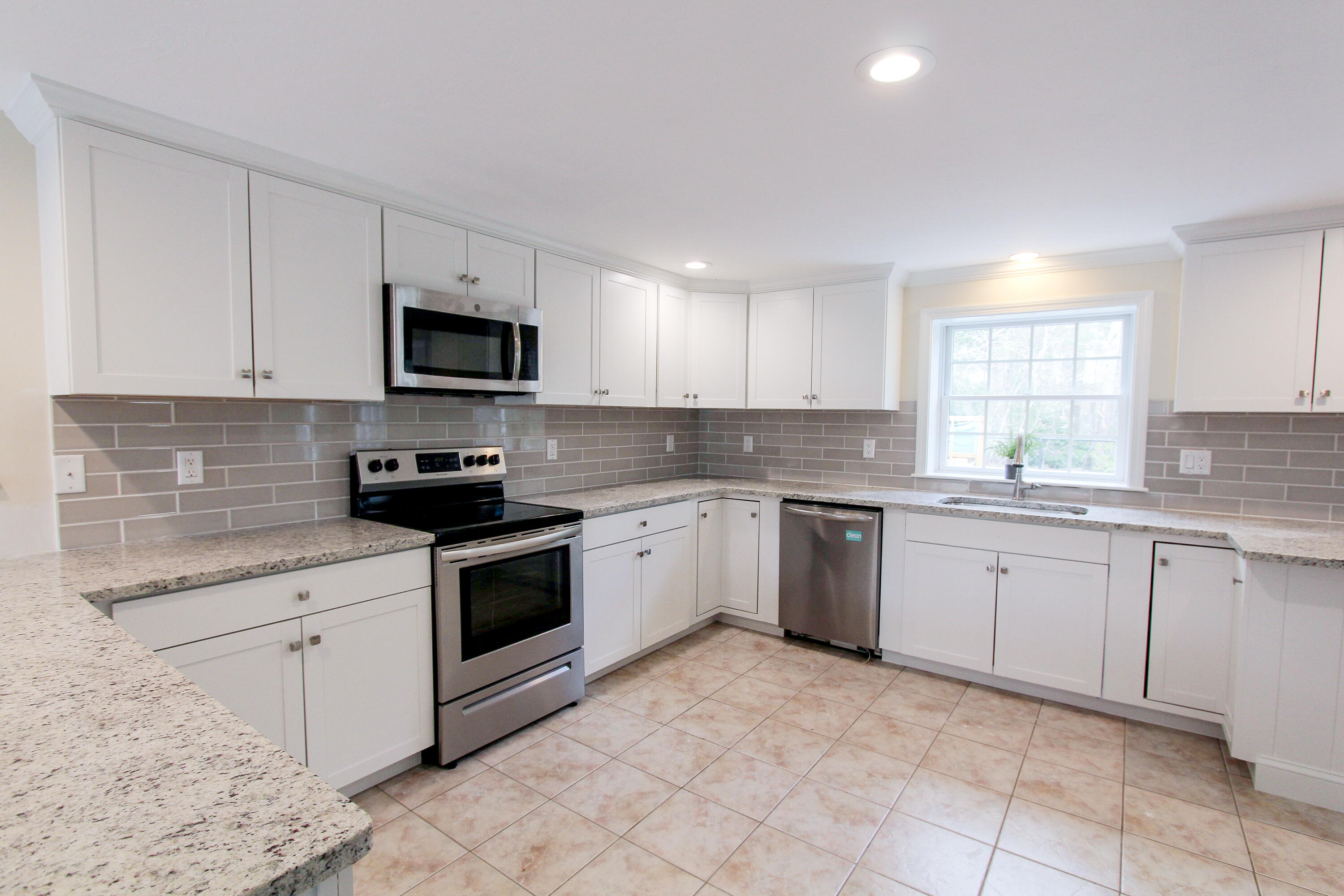 199 Skunknet Road Centerville, MA 02632 - Photo 11 of 37 a kitchen with granite countertop white cabinets sink and stainless steel appliances