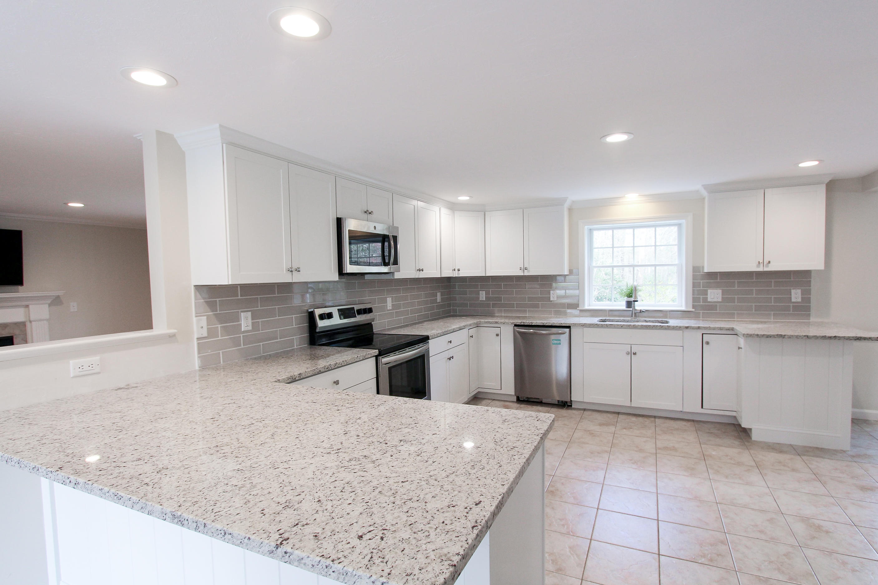 199 Skunknet Road Centerville, MA 02632 - Photo 2 of 37 a large kitchen with granite countertop a sink and white cabinets