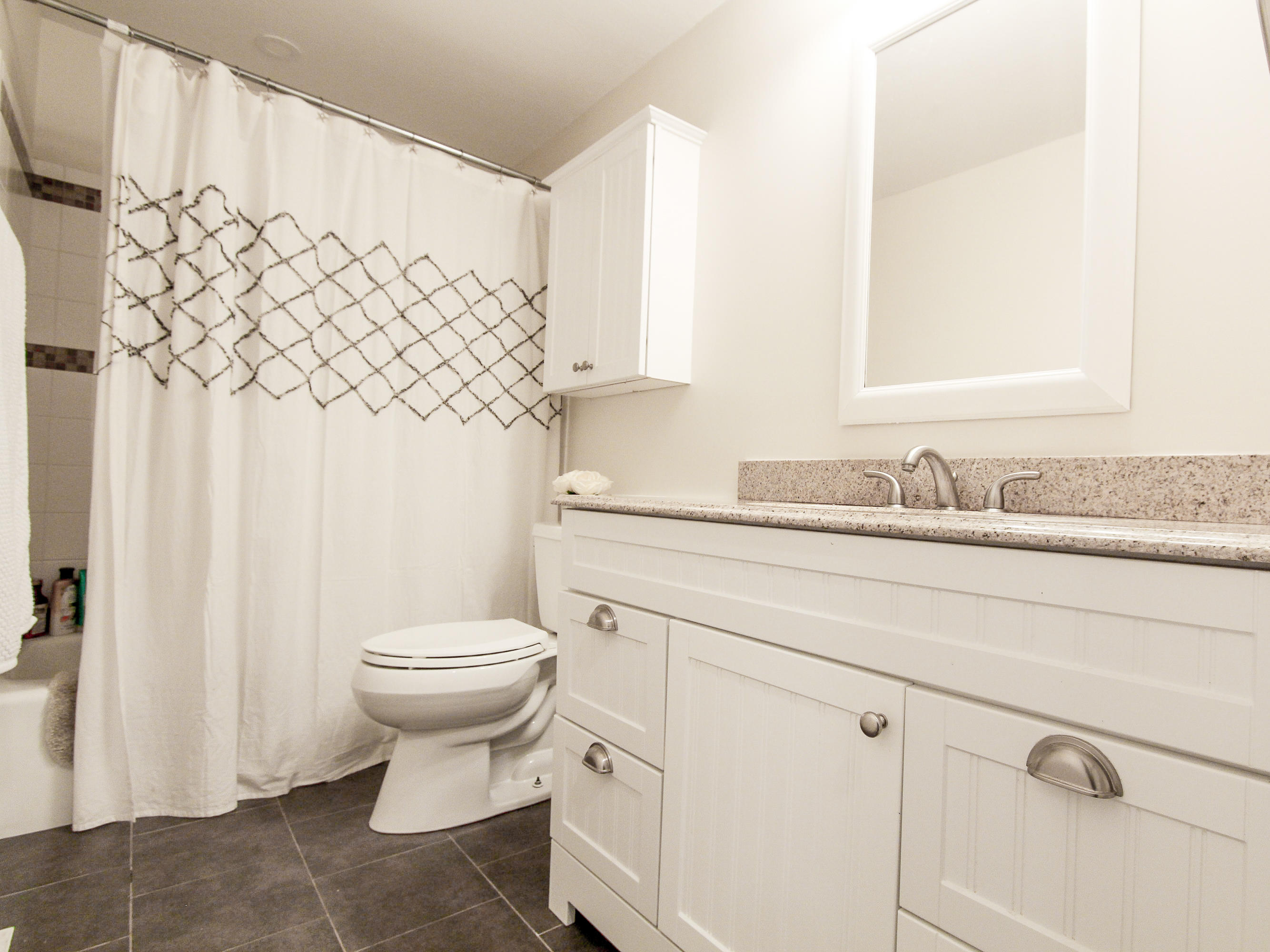 199 Skunknet Road Centerville, MA 02632 - Photo 24 of 37 a bathroom with a granite countertop toilet sink and mirror