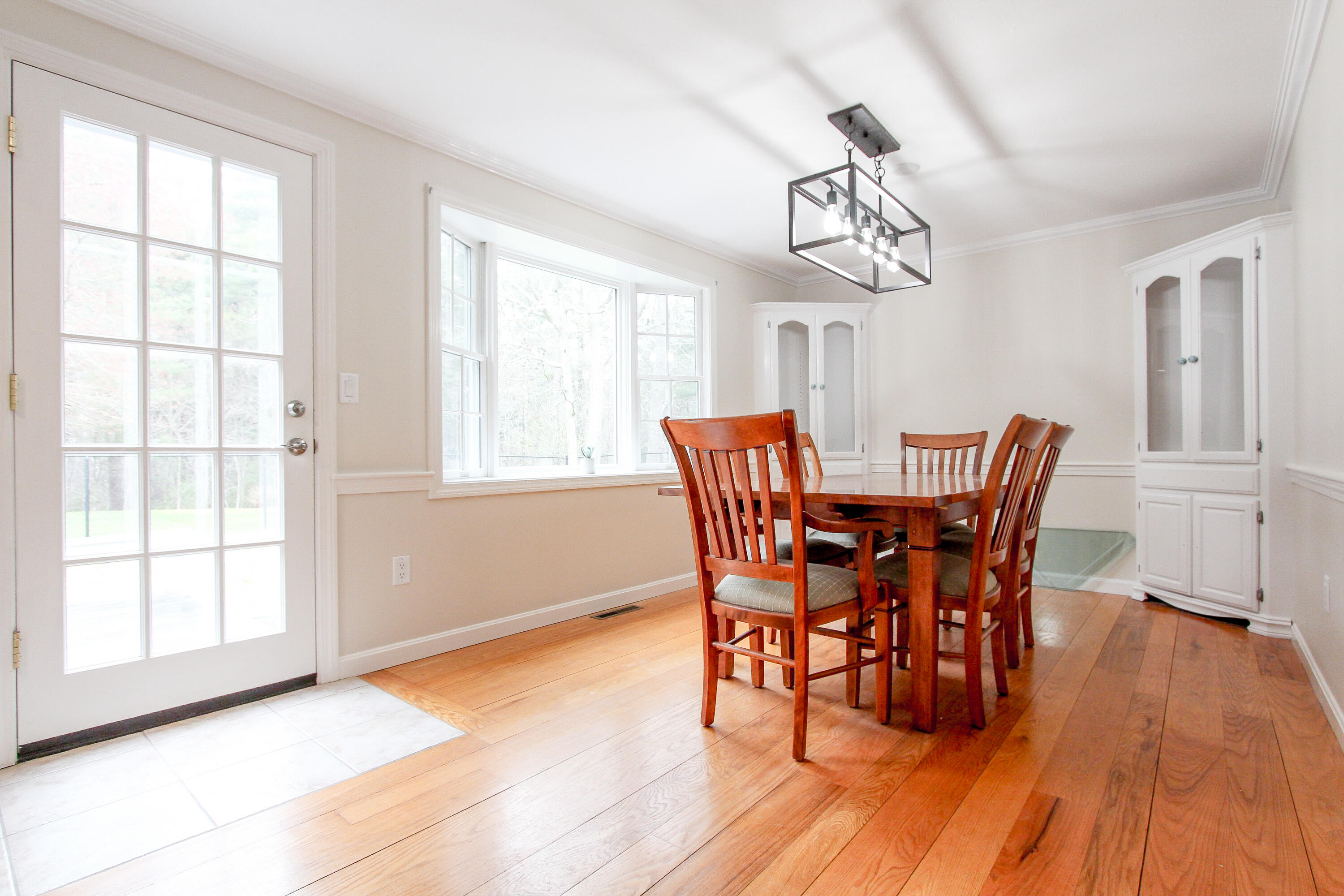 199 Skunknet Road Centerville, MA 02632 - Photo 3 of 37 a dining room with wooden floor a chandelier a wooden table and chairs