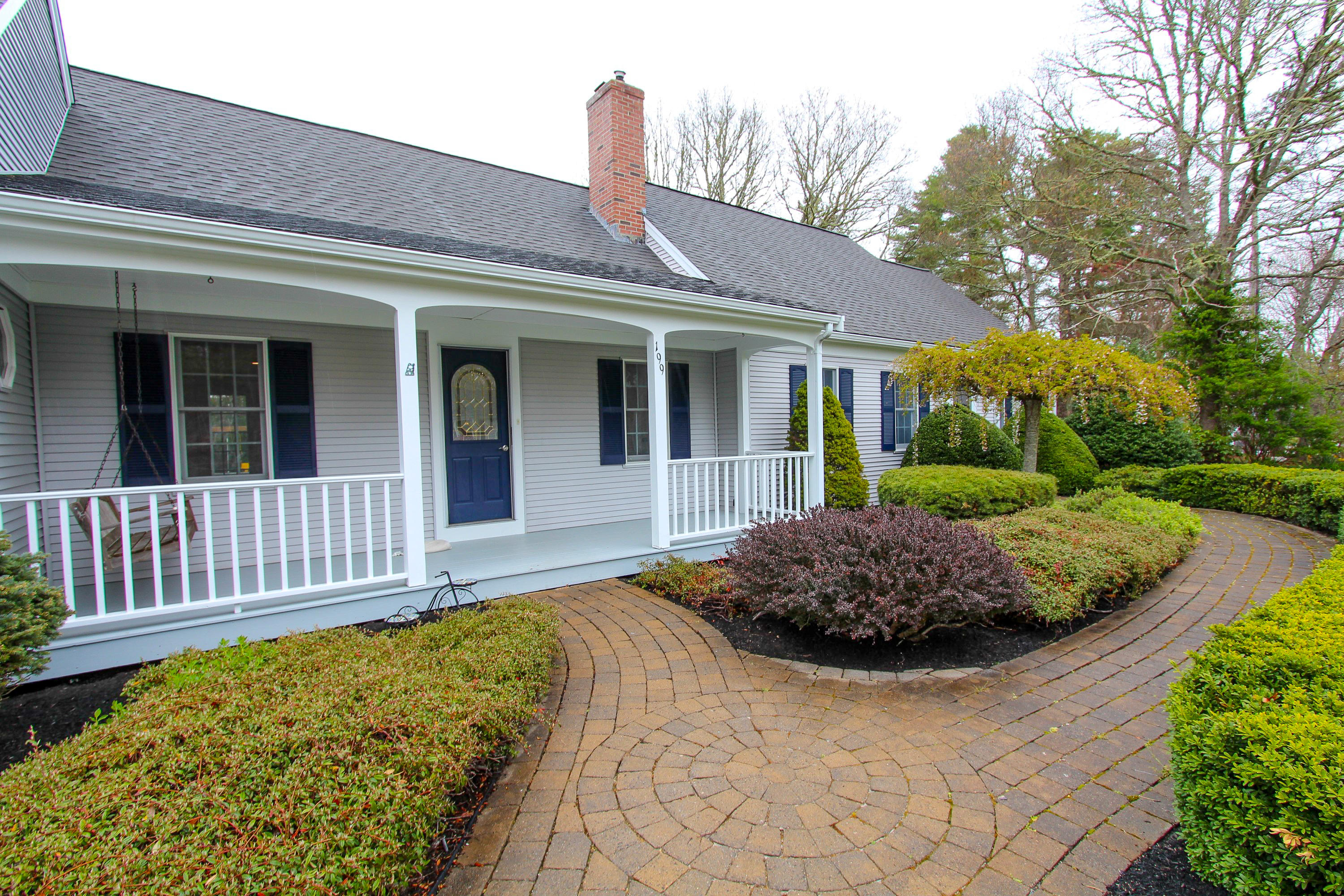 199 Skunknet Road Centerville, MA 02632 - Photo 35 of 37 a view of a house with a small yard and flower plants