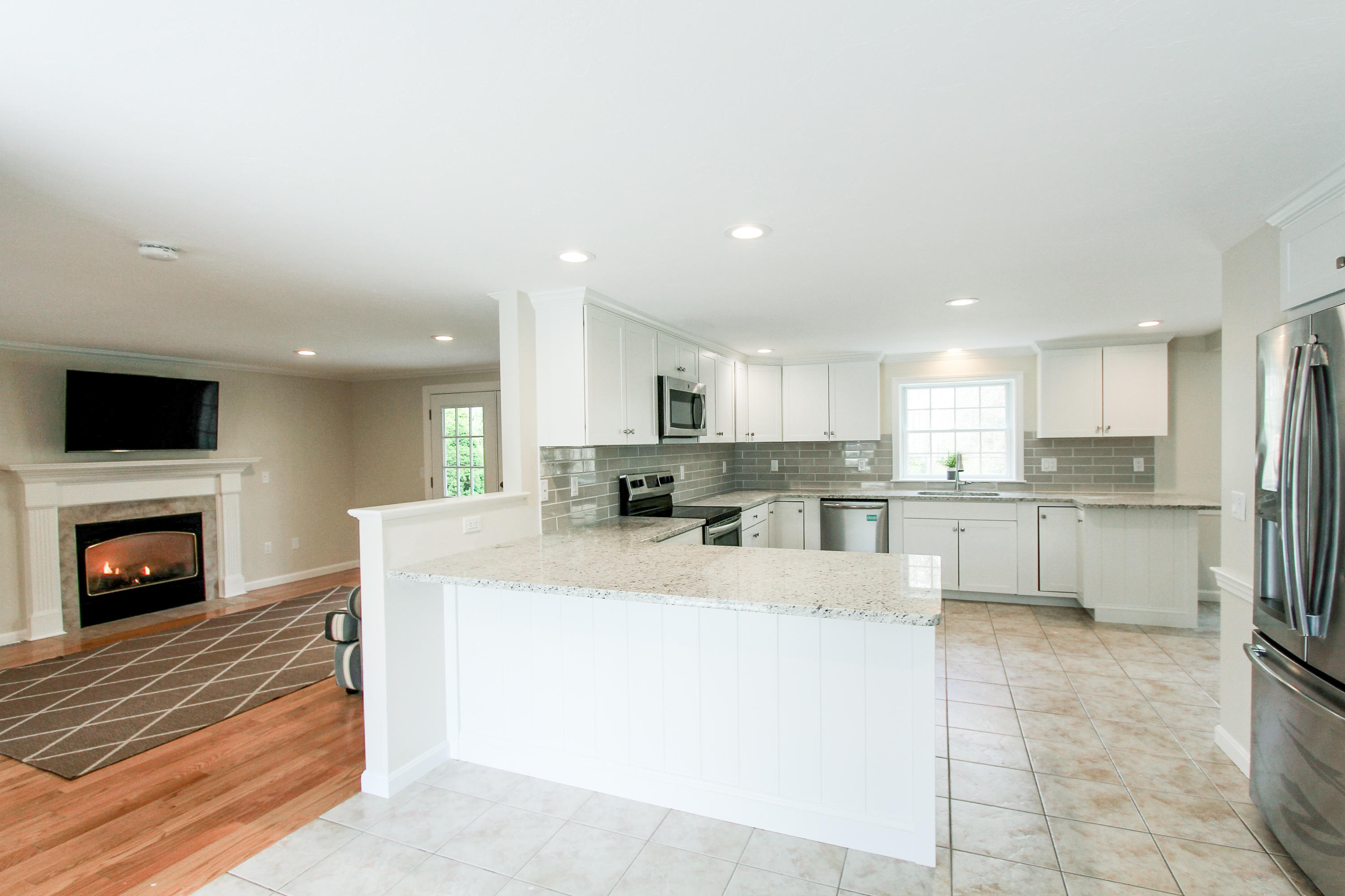 199 Skunknet Road Centerville, MA 02632 - Photo 37 of 37 a large white kitchen with a refrigerator a stove top oven and a fireplace