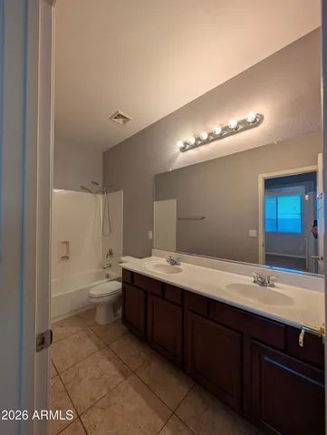 a bathroom with a double vanity sink mirror and toilet