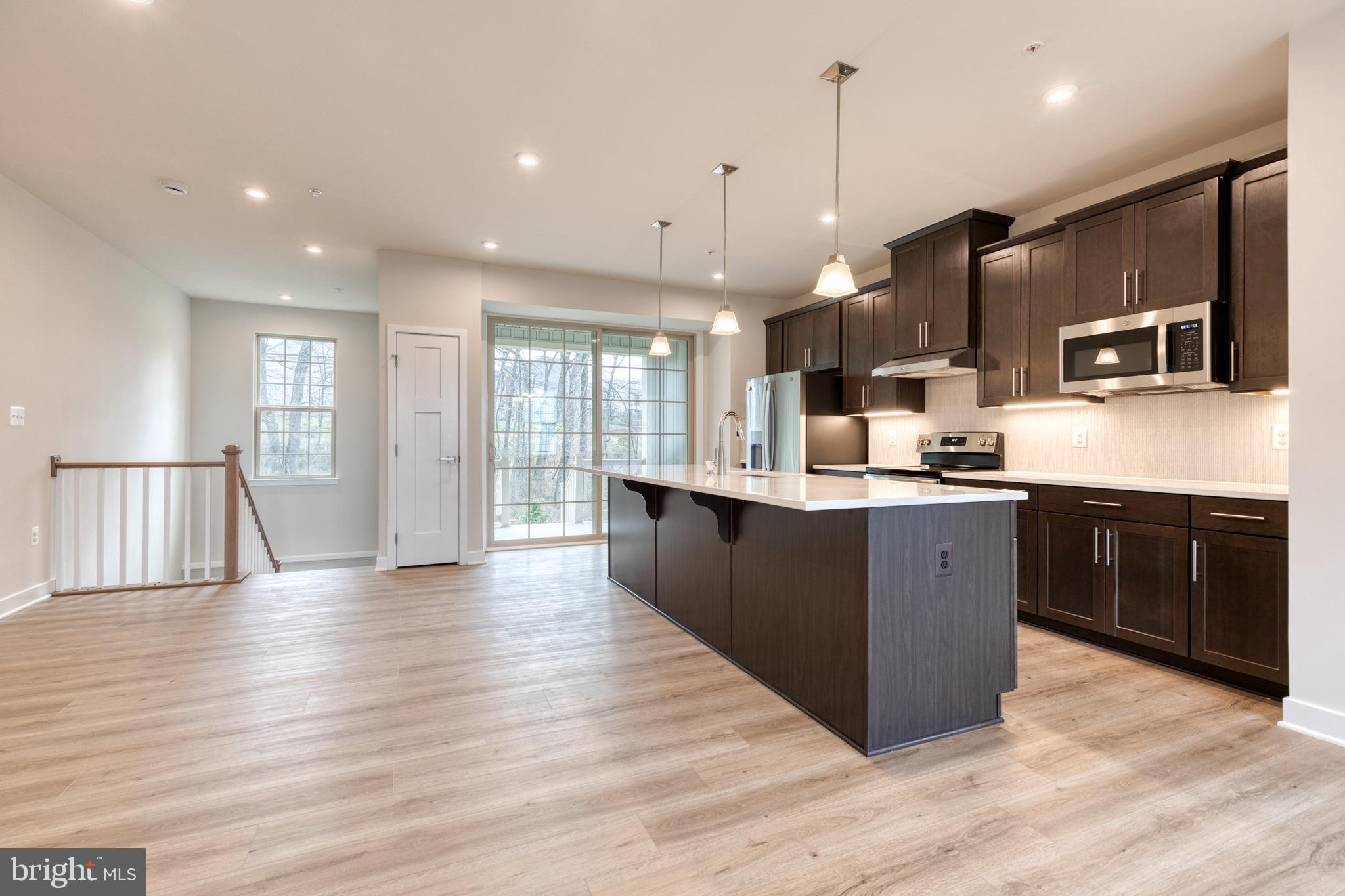 3433 Jacobs Ford Way Hanover, MD 21076 - Photo 16 of 37 a large kitchen with stainless steel appliances kitchen island a large counter top and a wooden floors