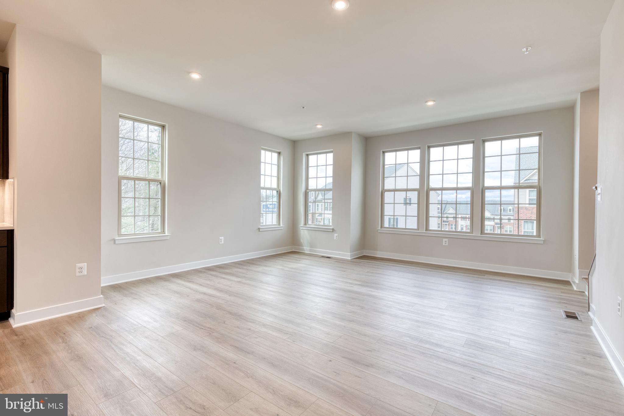 3433 Jacobs Ford Way Hanover, MD 21076 - Photo 22 of 37 an empty room with wooden floor and windows with curtains view